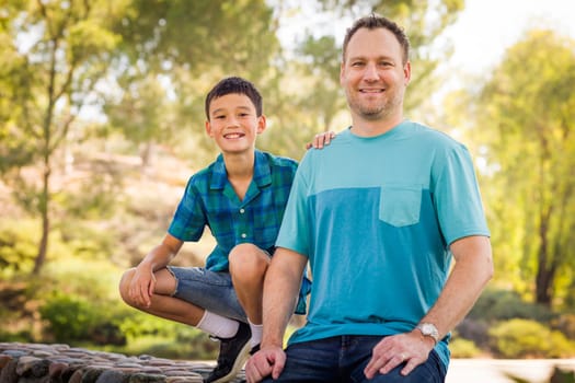 Outdoor portrait of biracial Chinese and Caucasian father and son.