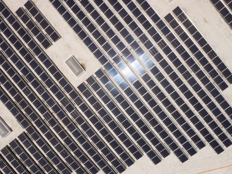 Aerial View of Solar Panels Mounted on Roof of Large Industrial Building or Warehouse.