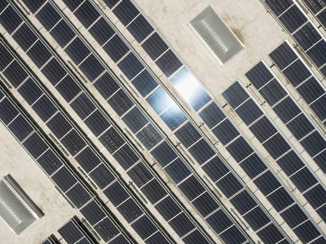 Aerial View of Solar Panels Mounted on Roof of Large Industrial Building or Warehouse.