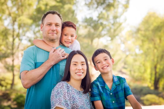 Outdoor portrait of biracial Chinese and Caucasian family.