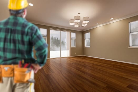 Contractor In Hard Hat and Construction Belt Facing Newly Remodeled House Room.