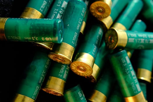 Shotgun shells on a black surface. Ammunition for 12 gauge smoothbore weapons. Hunting ammunition. Dark background