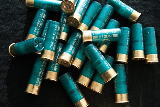Shotgun shells on a black surface. Ammunition for 12 gauge smoothbore weapons. Hunting ammunition. Dark background