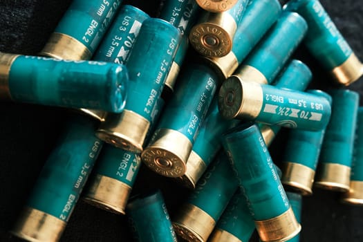Shotgun shells on a black surface. Ammunition for 12 gauge smoothbore weapons. Hunting ammunition. Dark background