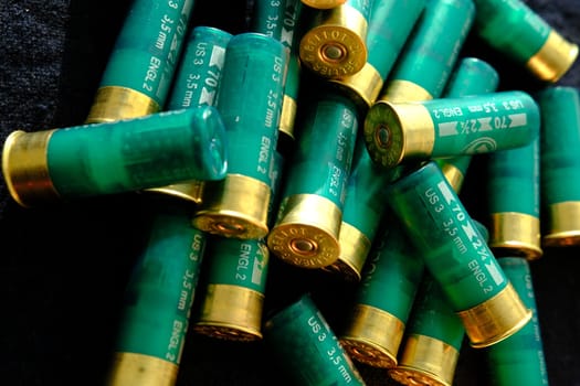 Shotgun shells on a black surface. Ammunition for 12 gauge smoothbore weapons. Hunting ammunition. Dark background