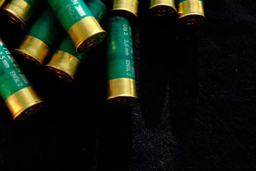Shotgun shells on a black surface. Ammunition for 12 gauge smoothbore weapons. Hunting ammunition. Dark background
