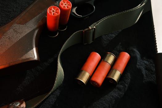 Weapon on black cloth: knife, rifle, shells,top view. Top view of knife, rifle shells