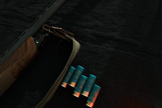 Weapon on black cloth: rifle, shells,top view. Top view of rifle, shells on black cloth background.
