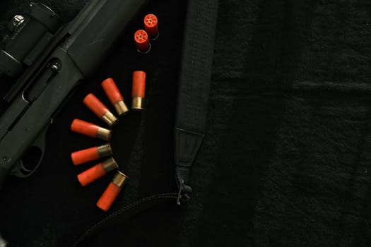 Weapon on black cloth: rifle, shells,top view. Top view of rifle, shells on black cloth background.