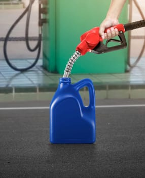 A man fills jerry cans at a gas station