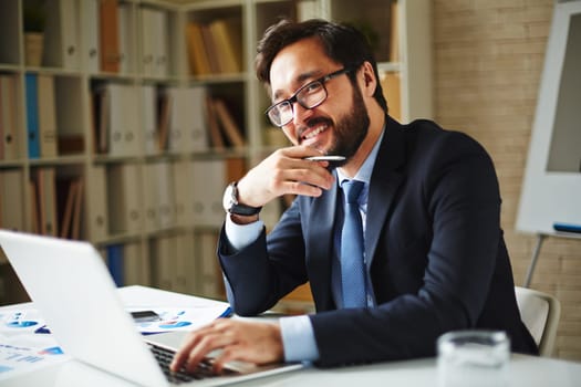 Elegant businessman in eyeglasses networking in office
