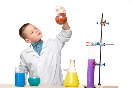 Little boy in a white coat as chemist doing experiment with multicolored chemical fluid in the laboratory isolated on white background