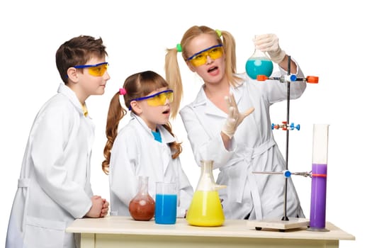 Teens and teacher of chemistry at chemistry lesson making experiments isolated on white background