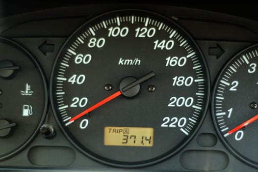 A close up of car dashboard with speed over black background