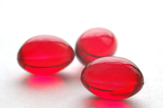 Close up of vitamins E pills, red capsules