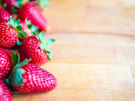 Arranged strawberries on a wooden board with empty space