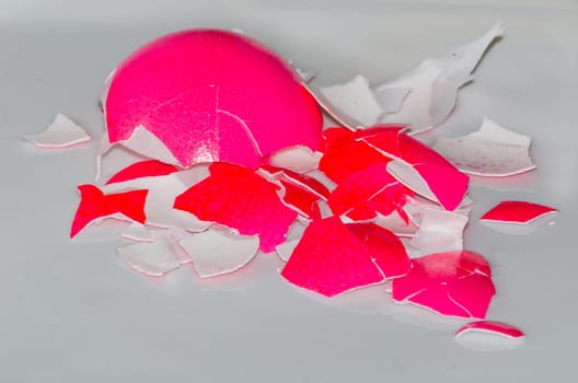 Eggshells on a plate of a red Easter egg.