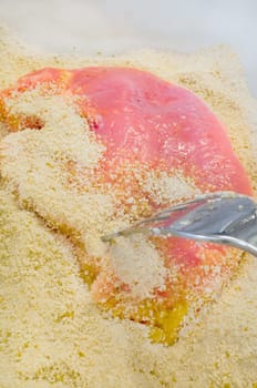 raw cutlet in breadcrumbs with on a fork.