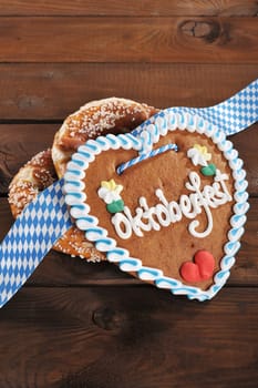 original Bavarian lye pretzels with Oktoberfest gingerbread heart in front of a wooden wall