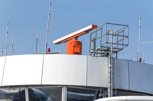 Air traffic control tower with radar system at an airport.
