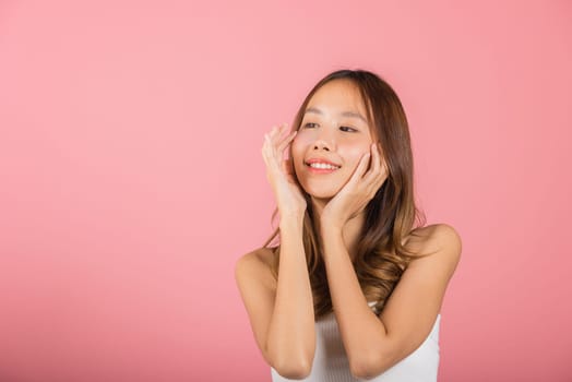 Femininity. Asian beautiful young woman smiling mask cosmetic patches gel under the eyes, Portrait female touching clean skin medical hydrogel eye patch on face, isolated on pink background, skincare