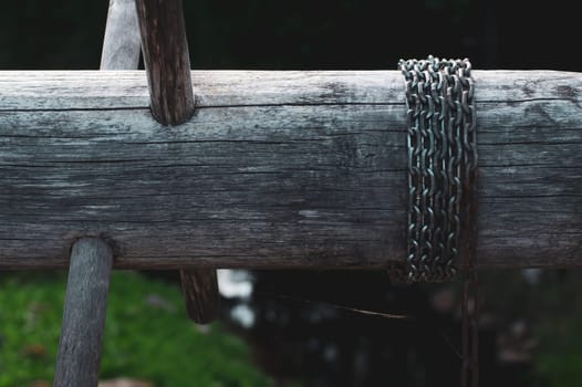 Old wooden winch of well with chain. lifting mechanism of water from the draw well