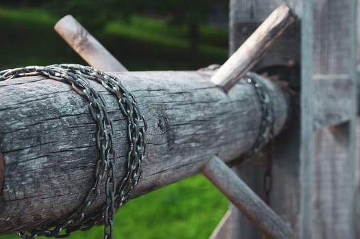 Old wooden winch of well with chain. lifting mechanism of water from the draw well