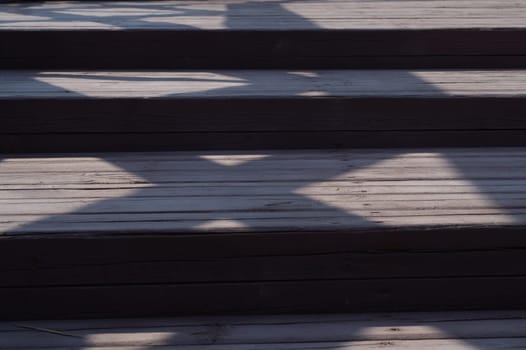 Wooden staircase with shadows close up