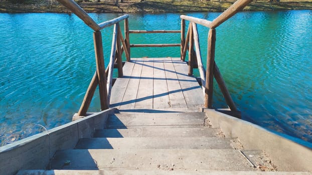 Azure clear water in a pond with wooden pier