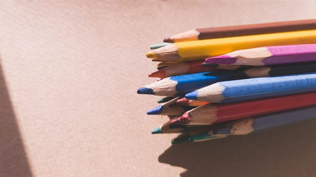 Bunch of colorful pencils on cardboard close up