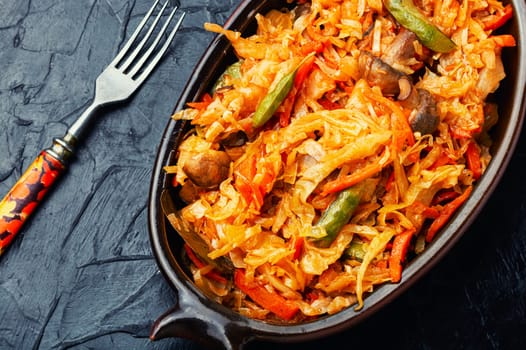 Tasty cabbage stewed with mushrooms and carrots. Lenten food.