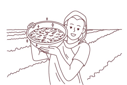 Smiling indian woman in traditional clothes show bowl working in field in countryside. Happy female worker collecting crop in rural grassland. Farming concept. Vector illustration.
