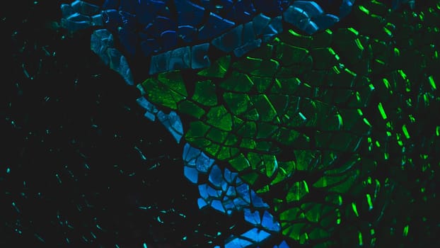 Shattered glass pattern in the dark. abstract cracked background. green and blue fragments