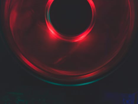 Red light of computer fan close up. cooler in action with leds. abstract background. power in motion concept