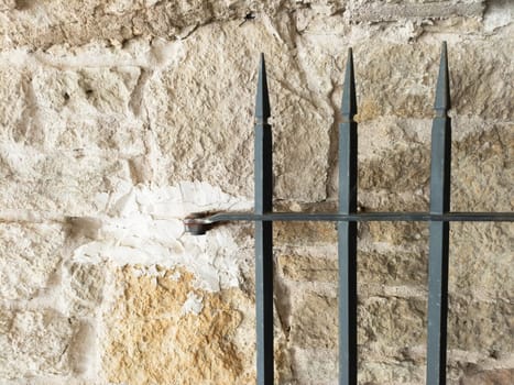 Old stone wall and iron fence with arrowheads