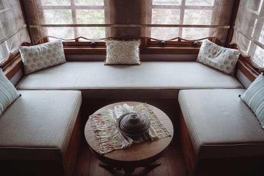 top view of divan with several pillows in front of window