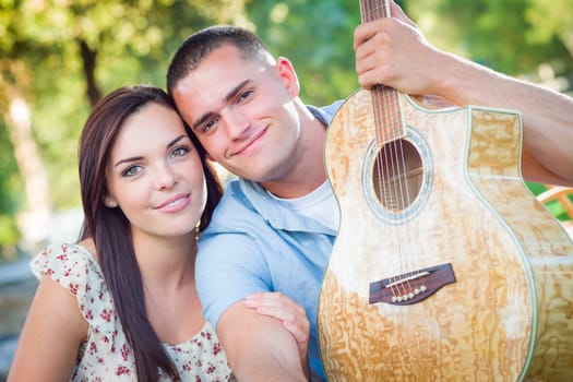 Young Adult Couple Portrait with Guitar in the Park.