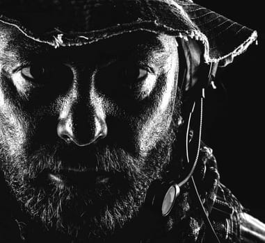 Special forces United States in Camouflage Uniforms studio shot. Wearing jungle hat, Shemagh scarf, painted face. Black background, bottom light colorized toned contour shor