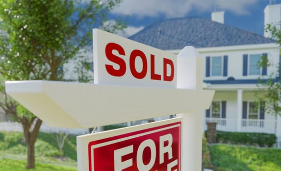 Close-up of Sold Placard On House For Sale Real Estate Sign In Front of New House.