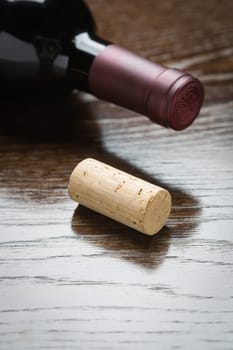 Wine Bottle and Cork on a Reflective Wood Surface Abstract.