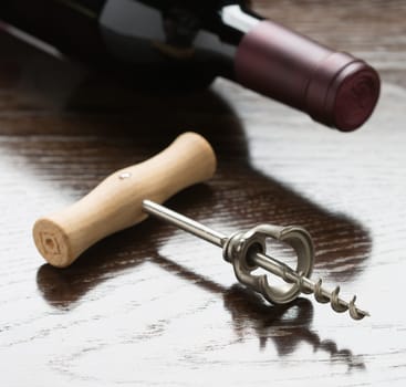 Abstract Wine Bottle and Corkscrew Laying on a Reflective Wood Surface.