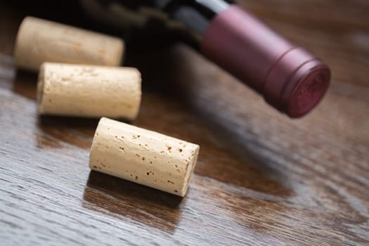 Wine Bottle and Corks on a Reflective Wood Surface Abstract.