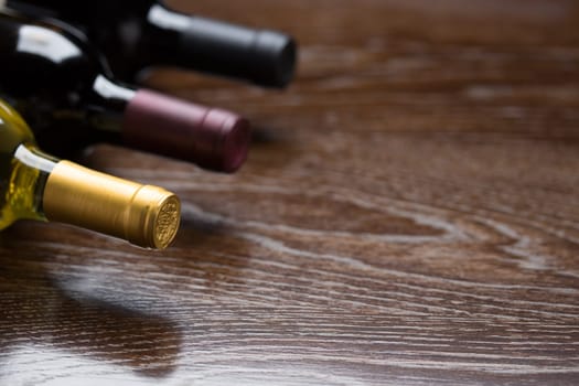 Various Wine Bottles on a Reflective Wood Surface Abstract.