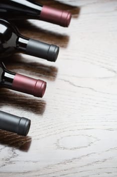 Various Wine Bottles on a Reflective Wood Surface Abstract.
