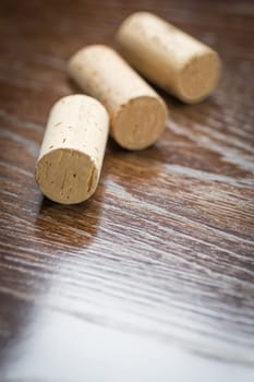 Blank Wine Corks Resting on Reflective wood Surface.