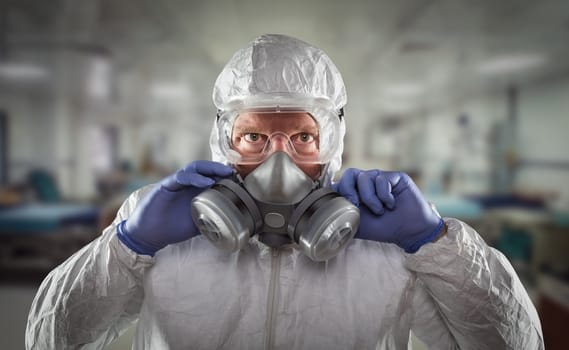 Man Wearing Hazmat Suit, Protective Gas Mask and Goggles Reaching To Stop with Hands Within Hospital.