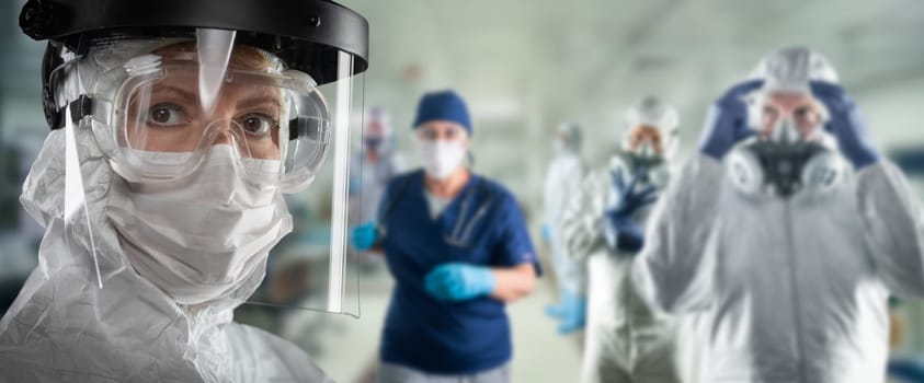 Team of Female and Male Doctors or Nurses Wearing Personal Protective Equiment In Hospital Emergency Room.