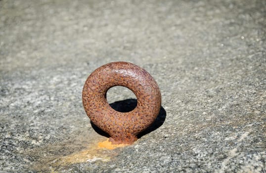 one rusty mooring loop for boat on the rock