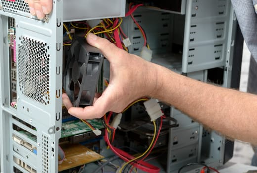 a technician changes the fan of a computer