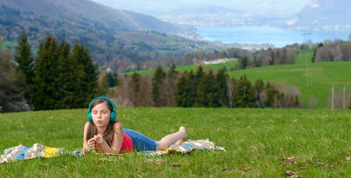 a pretty young girl listening to music in nature